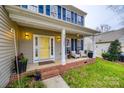 Brick front porch with yellow door and seating, creating welcoming curb appeal at 1345 Shimmer Light Cir, Rock Hill, SC 29732