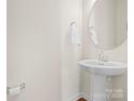 Small powder room with pedestal sink and round mirror at 236 Ascot Run Way, Fort Mill, SC 29715