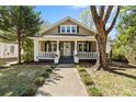 Charming home featuring a cozy front porch with stylish decor and lush landscaping at 507 W 2Nd Ave, Gastonia, NC 28052