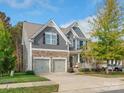 Two-story house with gray siding, stone accents, and a two-car garage at 9507 Inverness Bay Rd, Charlotte, NC 28278