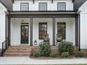 Inviting front porch with rocking chairs, brick steps, and a stylish black front door at 111 Alberta Ave, Belmont, NC 28012