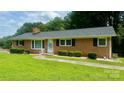 Charming brick ranch home with a well-maintained lawn, trimmed hedges, and a cozy front entrance at 2319 Tin Mine Rd, Lincolnton, NC 28092