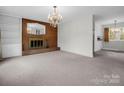Bright living room showcasing a brick fireplace, built-in shelving, and elegant chandelier at 2319 Tin Mine Rd, Lincolnton, NC 28092