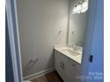 Modern powder room with white vanity, quartz countertop, and mirror at 4125 Black Ct # 169, Harrisburg, NC 28075