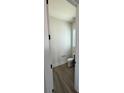 Compact half-bathroom with wood-look flooring, white toilet, and modern fixtures, ideal for guests at 7392 Deer Hollow Rd # 27, Sherrills Ford, NC 28673