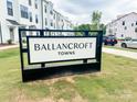 Ballancroft Towns community signage near a sidewalk and street featuring new construction townhomes in background at 13013 Moon Rd # 41, Charlotte, NC 28277