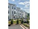 Street view of Ballancroft Towns, lined with new construction townhomes, landscaping and community signage at 13013 Moon Rd # 41, Charlotte, NC 28277