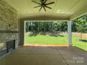 Relaxing covered patio with stone fireplace and ceiling fan overlooking the private backyard at 2007 Kendall Dr # 6, Wesley Chapel, NC 28173