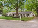 Charming home with a lush lawn, mature trees, and a painted brick exterior at 1102 Oak Hill Dr, Monroe, NC 28112