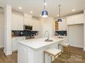 Modern kitchen featuring a large center island, stainless steel appliances, and stylish backsplash at 165 Halite Ln, Waxhaw, NC 28173