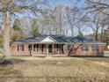 Brick ranch house with a covered porch and landscaped yard at 131 Nantz Ave, Mount Holly, NC 28120