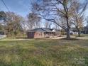 Side view of the brick ranch house showcasing its landscaping at 131 Nantz Ave, Mount Holly, NC 28120