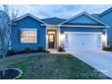 Inviting home with a wreath on the front door and a warm glow from the window at dusk at 138 Gray Willow St, Mooresville, NC 28117