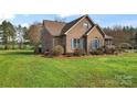 Brick home with blue shutters, complemented by mature landscaping and a spacious lawn at 158 White Rd, Wadesboro, NC 28170