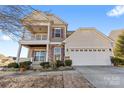 Two-story house with beige siding, a large garage, and landscaping at 160 Millen Dr, Mooresville, NC 28115