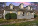 Two-story home with white brick exterior, dormer windows, and a front porch at 8478 Rocky River Rd, Harrisburg, NC 28075