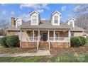 Brick ranch home with covered porch, landscaping, and a welcoming front entrance at 8478 Rocky River Rd, Harrisburg, NC 28075