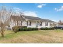 Street view of a one story house with manicured lawn, black roof and attached carport at 1976 Mcilwain Rd, Lancaster, SC 29720