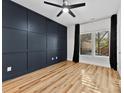 Spacious bedroom with dark blue accent wall, hardwood floors, and large windows at 327 Coxe Ave, Charlotte, NC 28208