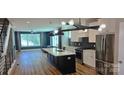 Open-concept living space featuring a kitchen with an island, and modern lighting at 327 Coxe Ave, Charlotte, NC 28208