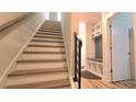 Staircase with wooden treads and black metal railing leading to a landing with built-in storage at 327 Coxe Ave, Charlotte, NC 28208