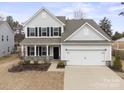 Charming two-story home featuring a well-manicured lawn, black shutters, and an attached two-car garage at 4551 Selhurst Dr, Indian Land, SC 29707