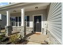 Inviting front porch with stone columns and a charming entryway at 4551 Selhurst Dr, Indian Land, SC 29707