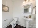 Modern powder room with pedestal sink and dark floor tile at 5110 Pansley Dr, Charlotte, NC 28226