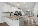 Open kitchen featuring white cabinets, stainless steel appliances, granite countertops, and hardwood floors at 547 Old Mill Rd, Charlotte, NC 28206