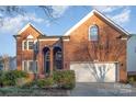 Two-story home with attached garage and landscaping at 6239 Oxwynn Ln, Charlotte, NC 28270