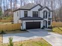 Two-story home featuring a painted brick exterior, dark trim, a two-car garage, and a spacious driveway at 1308 Pleasant Plains Rd, Matthews, NC 28105