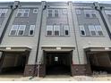Townhome showing three open garages with brick accents, offering convenient parking at 1316 Walter Taylor Way # Eqx0103, Charlotte, NC 28206