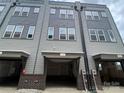 Townhome garages feature brick accents and access to the home at 1320 Walter Taylor Way # Eqx0102, Charlotte, NC 28206