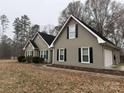 Gray house with black shutters, a black roof, and a detached garage at 13410 Old Camden Rd, Midland, NC 28107