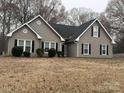 Gray house with black shutters, a black roof, and a well-maintained lawn at 13410 Old Camden Rd, Midland, NC 28107