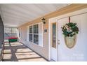 Covered front porch with white door, wreath, and ample light, offering a cozy and inviting entrance to the home at 150 Windmill Ct, Harmony, NC 28634