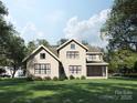 Two-story home with a lush green lawn, large windows, screened in porch, and mature trees on a sunny day at 3814 Topsfield Rd, Charlotte, NC 28211