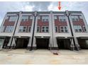 Rear view of modern townhomes with covered parking, neutral siding and brick accents at 1611 Polk St # Eqx0209, Charlotte, NC 28206