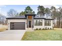 Stylish light brick home with a modern front door and landscaping at 10614 Arlington Church Rd, Charlotte, NC 28227