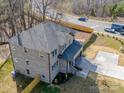 Aerial view of a brick two-story home featuring a spacious driveway and well-manicured landscaping at 1304 Pleasant Plains Rd, Matthews, NC 28105