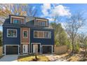 Modern two-unit building, navy and brown, with attached garages and fenced yards at 137 S Smallwood Pl, Charlotte, NC 28208