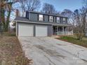 Two-story house with gray siding, white garage doors, and a covered porch at 4830 Carnbrook Pl, Charlotte, NC 28212