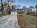 Two-story house with gray siding, white garage doors, and a covered porch at 4830 Carnbrook Pl, Charlotte, NC 28212