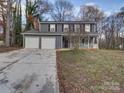 Gray sided two-story house with attached two-car garage and a front porch at 4830 Carnbrook Pl, Charlotte, NC 28212