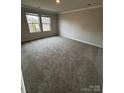 An empty bedroom with neutral walls, carpet, and two windows offering natural light at 102 Alden Ct, Shelby, NC 28152