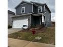 Two-story home with gray siding, stone accents, two-car garage, and small front yard with 'available' sign at 102 Alden Ct, Shelby, NC 28152