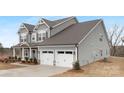 Gray two-story house with white garage doors and landscaping at 13026 Arnold Palmer Cir # 1051, Lancaster, SC 29720