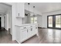 White kitchen with island, stainless steel appliances, and dark hardwood floors at 5442 Kinsale Ln, Charlotte, NC 28215