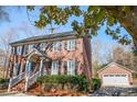 Two-story brick home with a detached garage and manicured landscaping at 1103 Hulston Ct, Charlotte, NC 28211