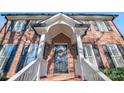 Front entrance with black door, white railings, and brick facade at 1103 Hulston Ct, Charlotte, NC 28211